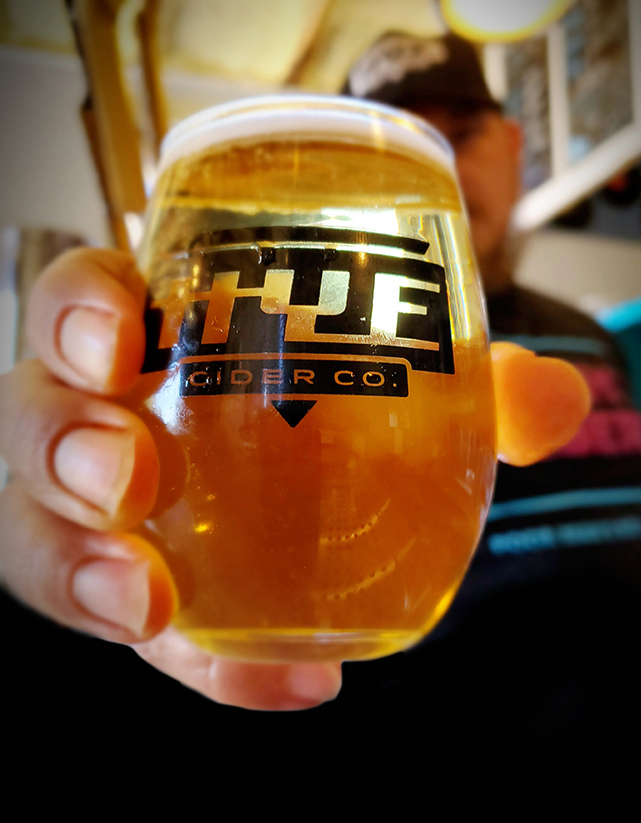 Hye Cider Company staff holding a glass of cyser